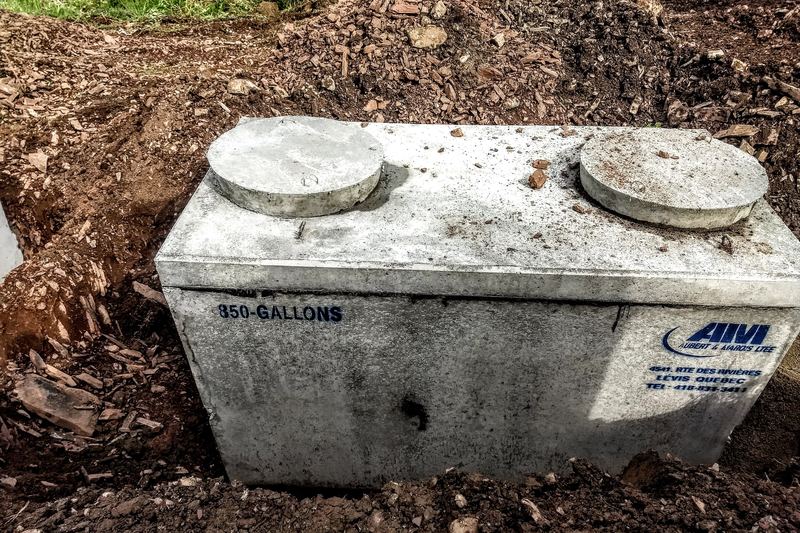 Precast concrete septic tank placed in the ground with two access lids
