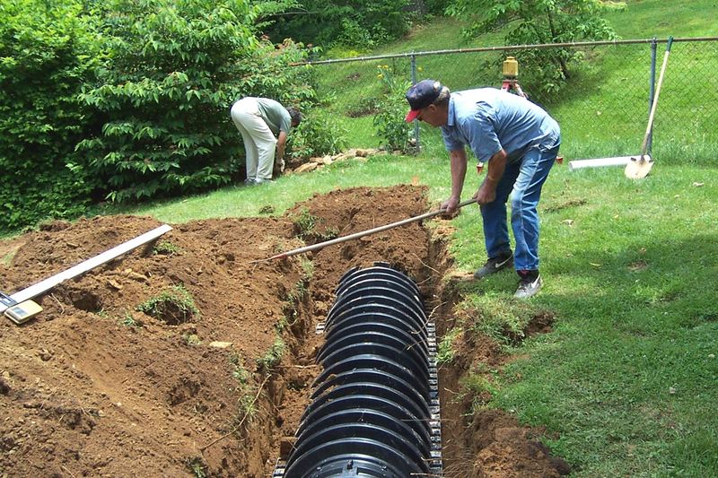 Installer setting leaching chambers in a trench